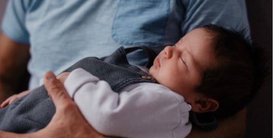 Schlafendes Baby im Arm